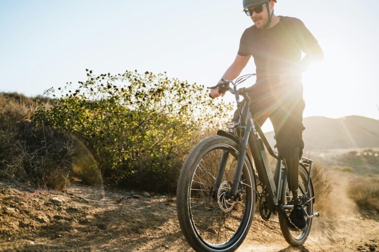 Rider on an electric bike on a dirt trail at sunset